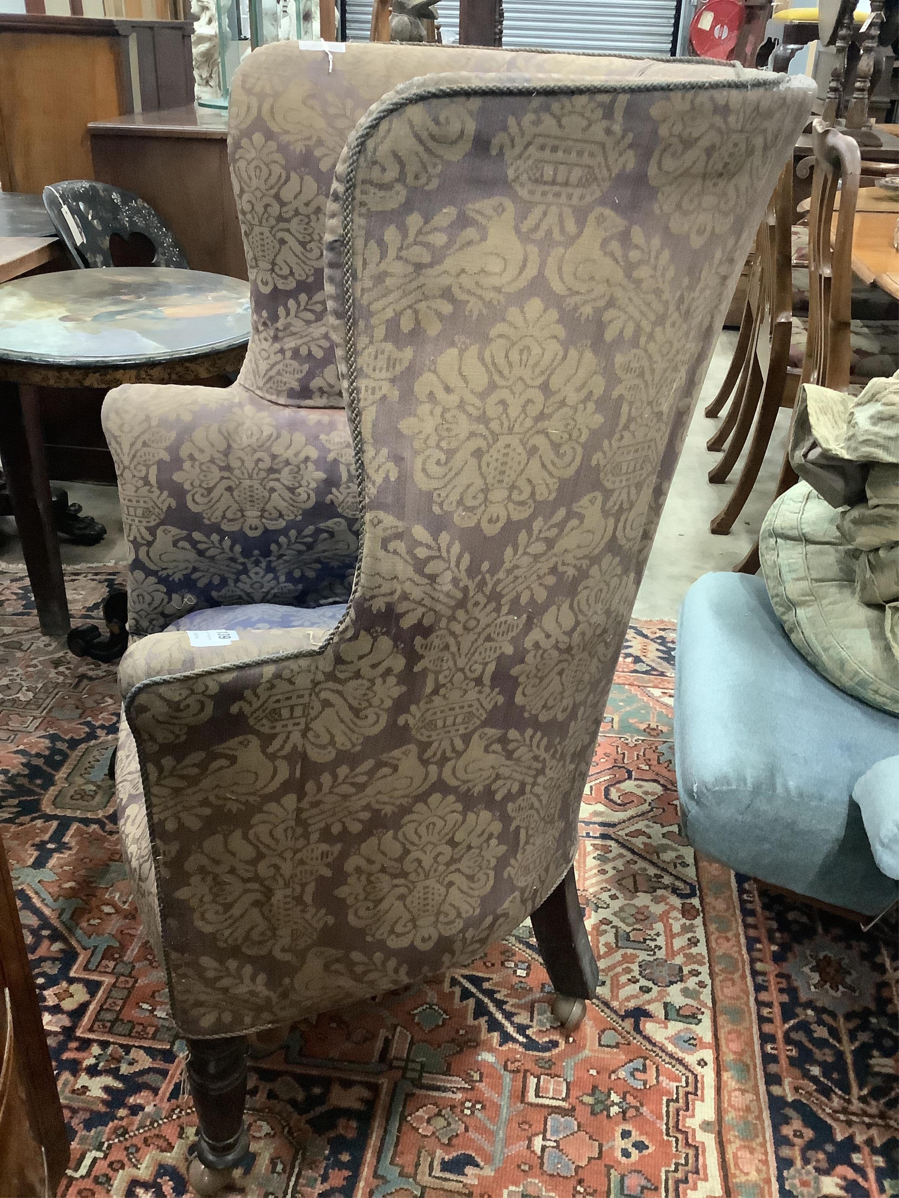 An early 19th century upholstered tub framed wing armchair, width 73cm, depth 55cm, height 113cm. Condition - fair